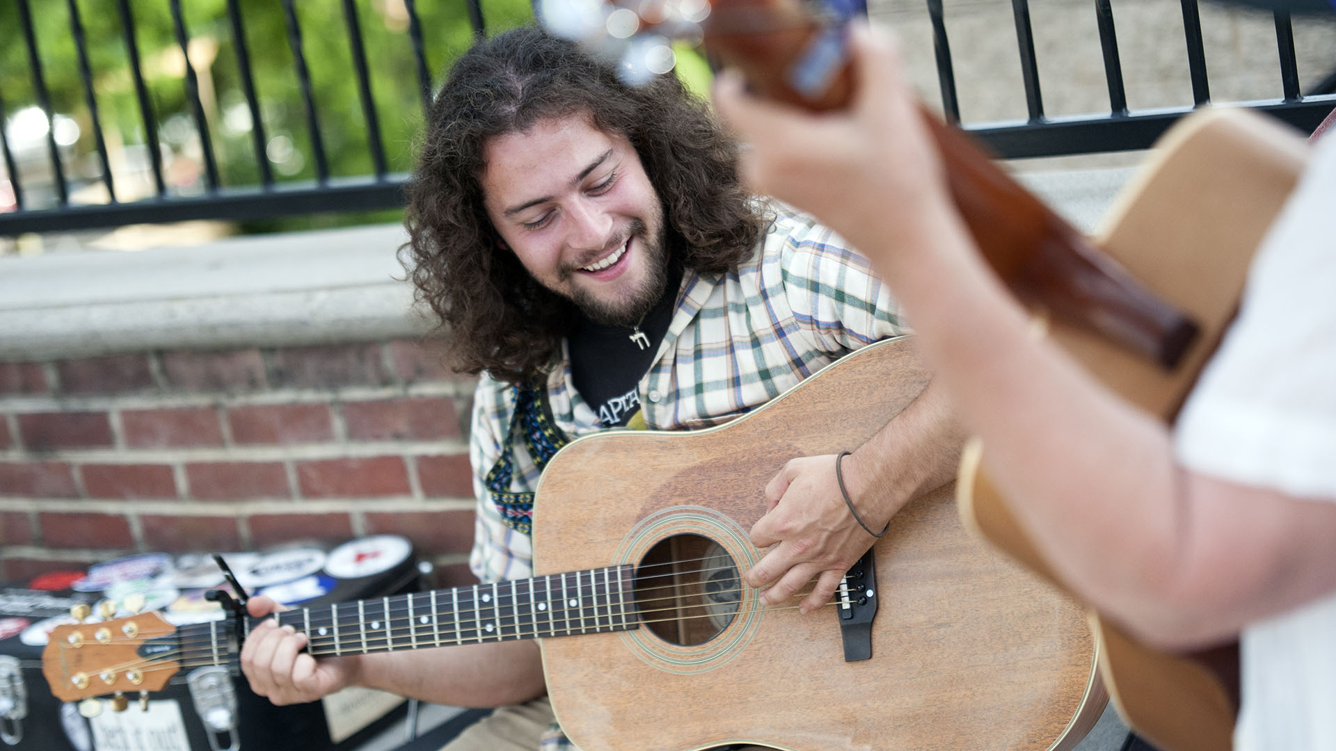 Jake Retting plays guitar along Locust Street in picturesque Floyd, Virginia.